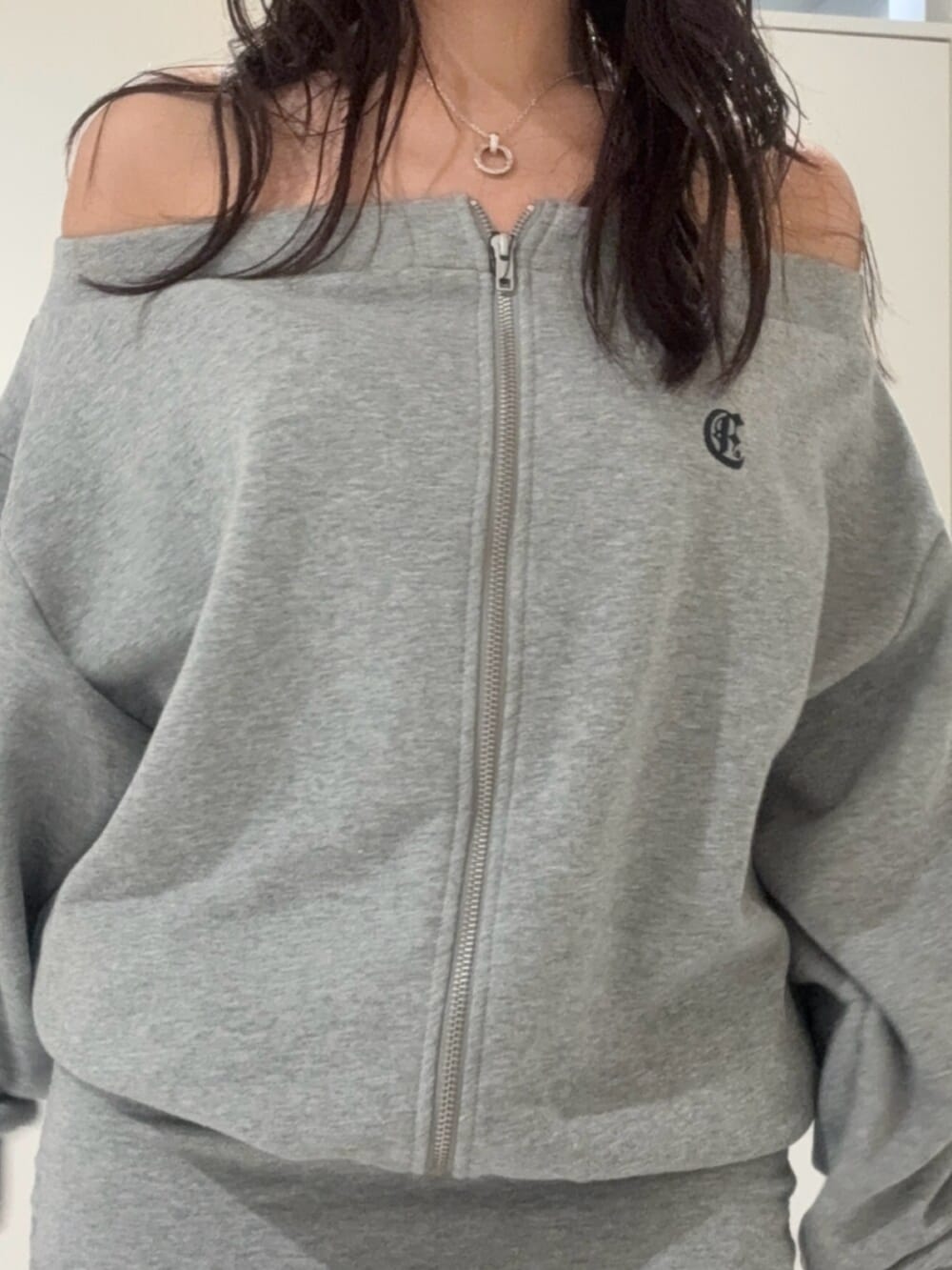 ブラック系のブーツ、グレー系のパーカー、ブルー系のデニムパンツを着用したレディースの秋コーディネートの4枚目の写真