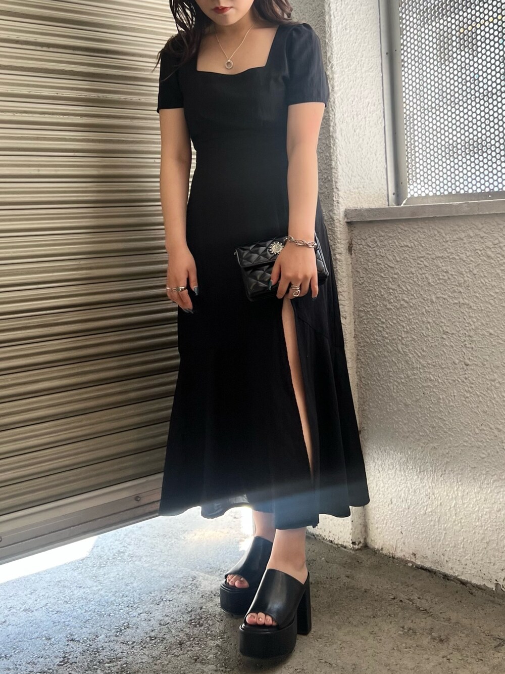 ブラック系のワンピース、ブラック系のショルダーバッグ、ブラック系のサンダルを着用したレディースの夏コーディネートの2枚目の写真