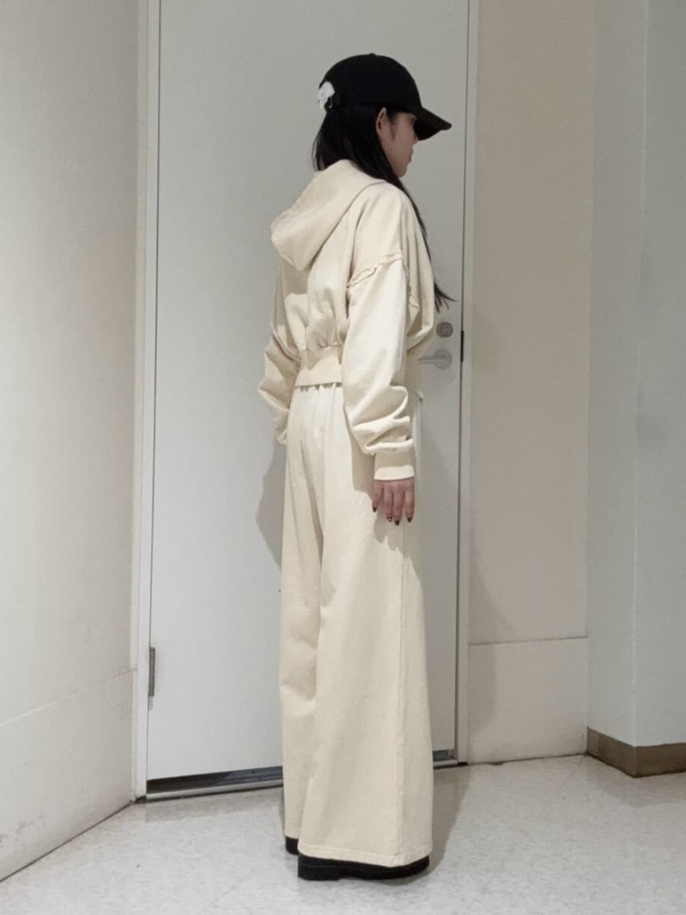 ブラック系のブーツ、ホワイト系のパーカー、ホワイト系のスウェットパンツを着用したレディースの春コーディネートの2枚目の写真