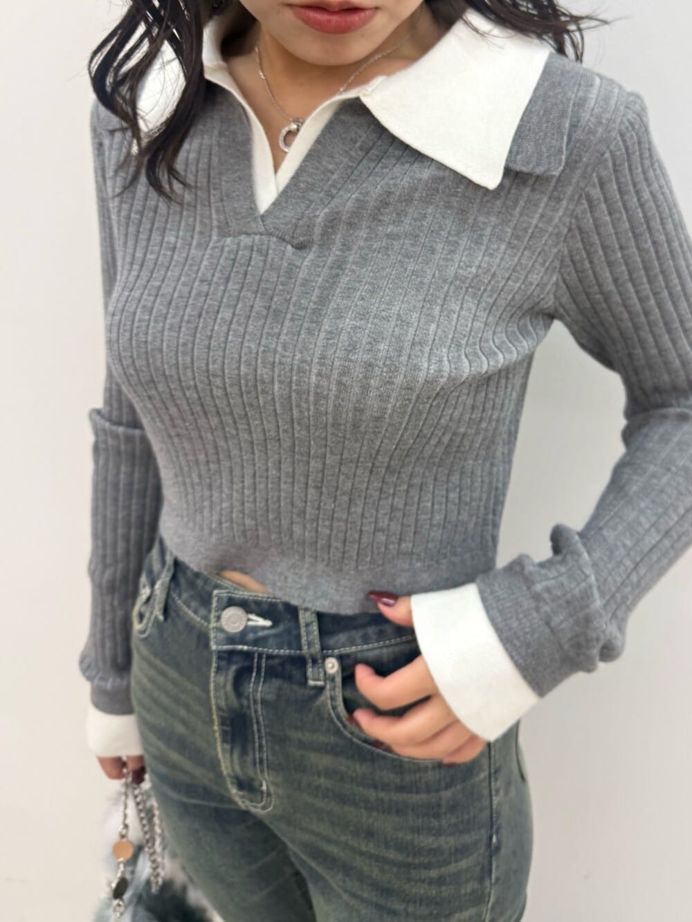 ブラック系のブーツ、グレー系のニット/セーター、ブルー系のデニムパンツを着用したレディースの秋コーディネートの4枚目の写真