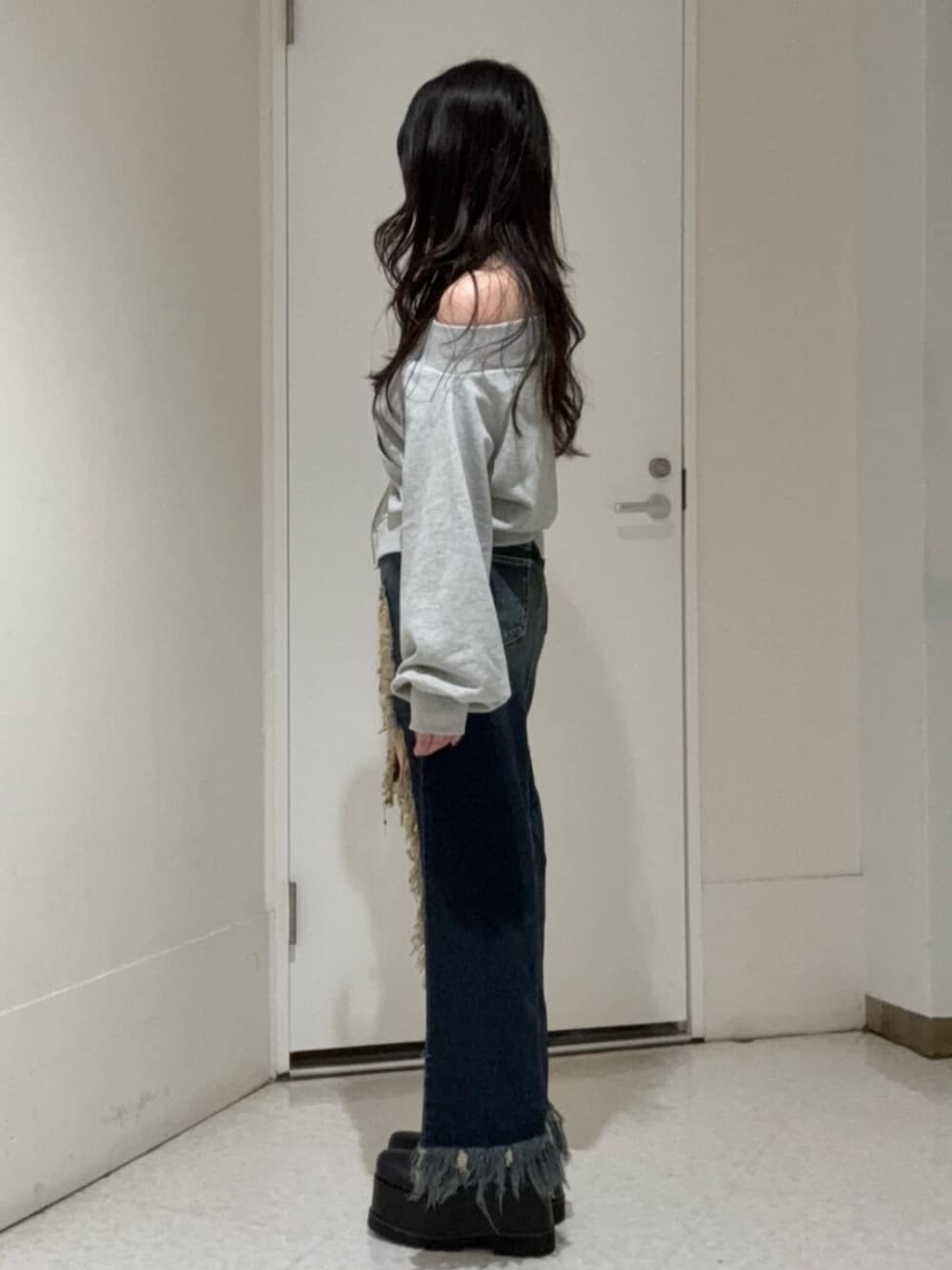 ブラック系のブーツ、ブルー系のデニムスカート、グレー系のスウェットを着用したレディースの冬コーディネートの2枚目の写真