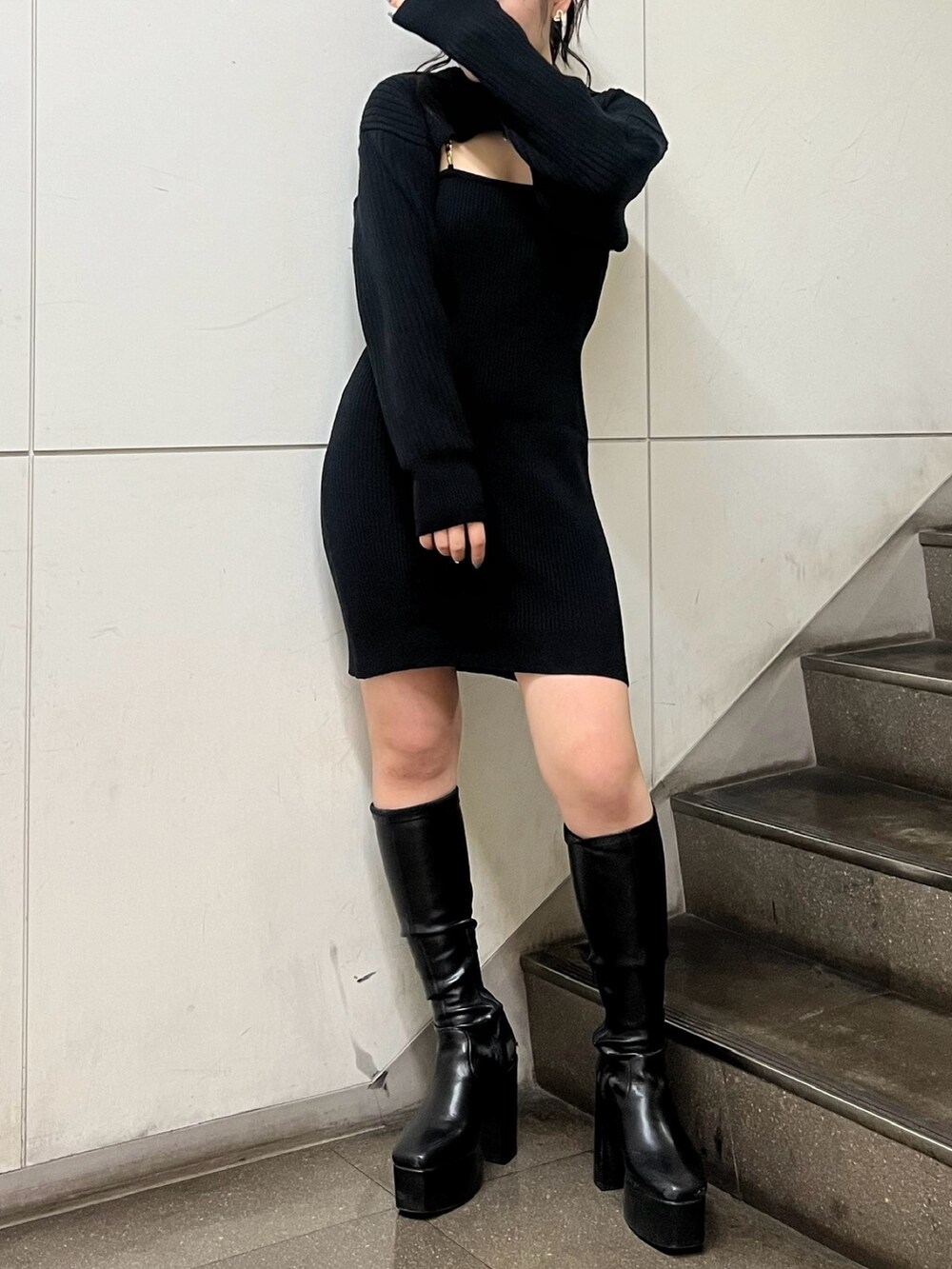 ブラック系のワンピース、ブラック系のブーツを着用したレディースの冬コーディネートの2枚目の写真