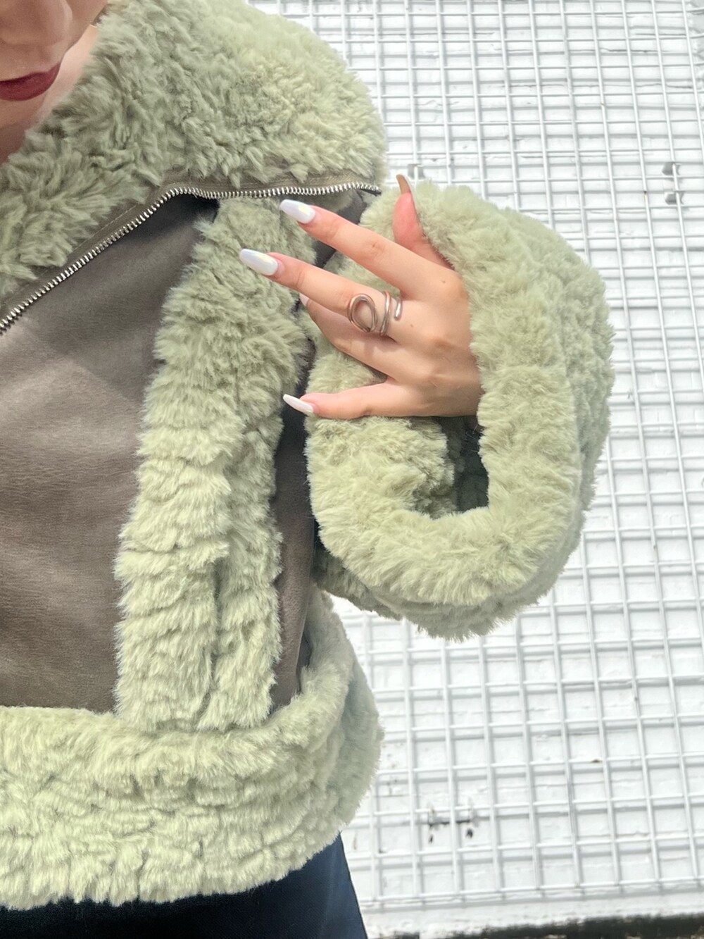 ブラック系のその他パンツ、ブラック系のブーツ、グリーン系のムートンコートを着用したレディースの夏コーディネートの6枚目の写真