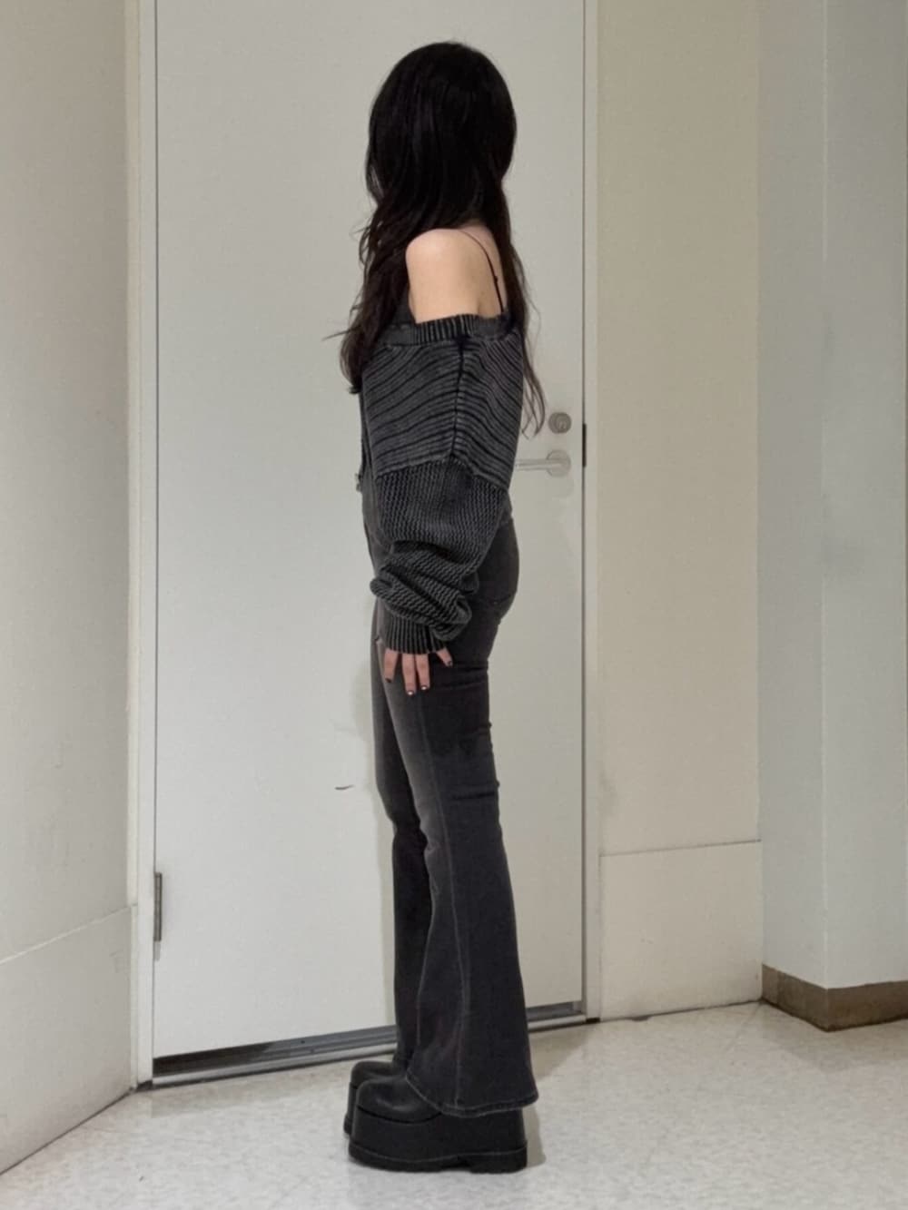 ブラック系のデニムパンツ、ブラック系のブーツ、ホワイト系のカーディガン/ボレロを着用したレディースの春コーディネートの2枚目の写真