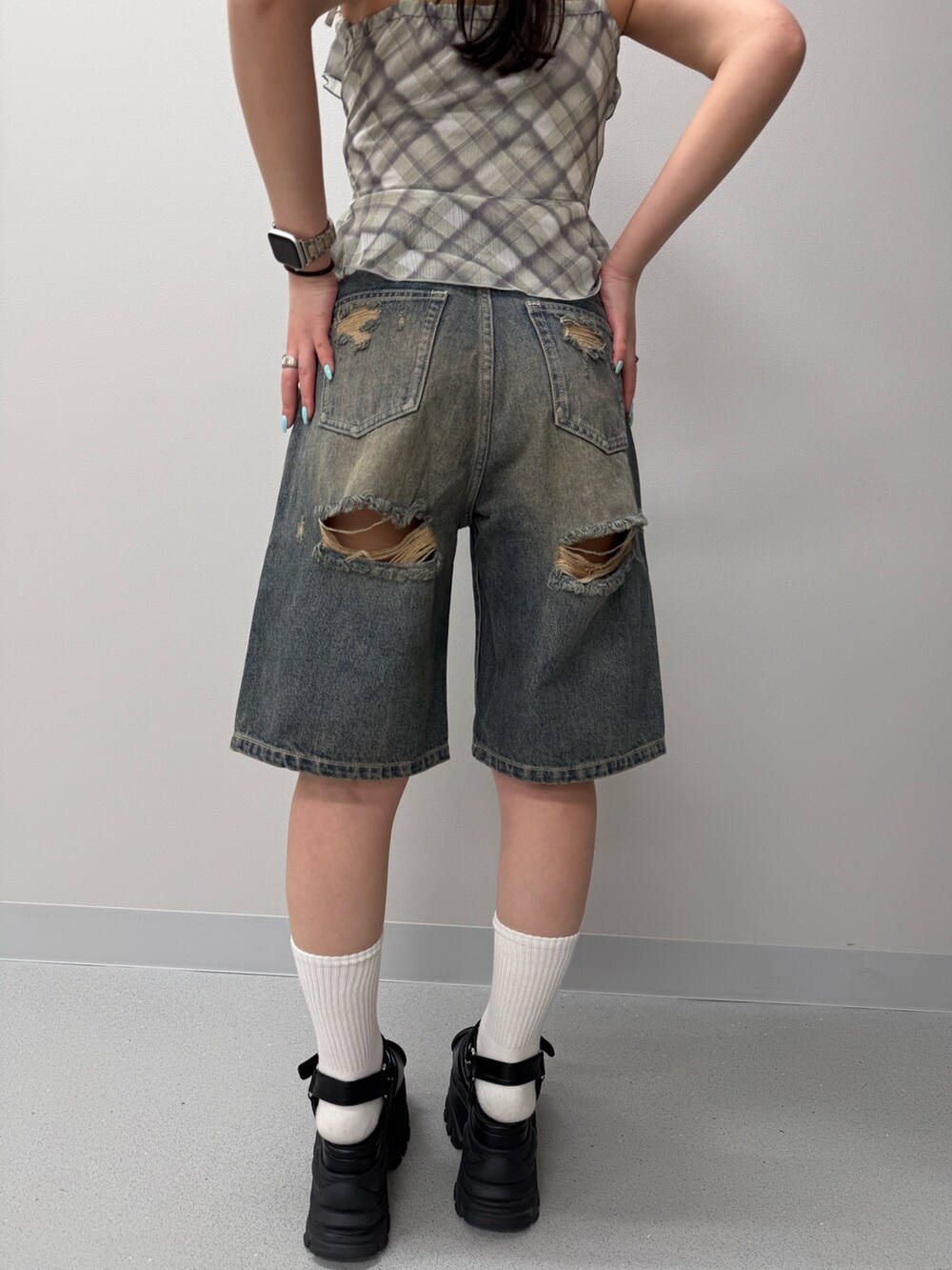 ブルー系のデニムパンツ、イエロー系のキャミソール、ブラウン系のサンダルを着用したレディースの春コーディネートの4枚目の写真