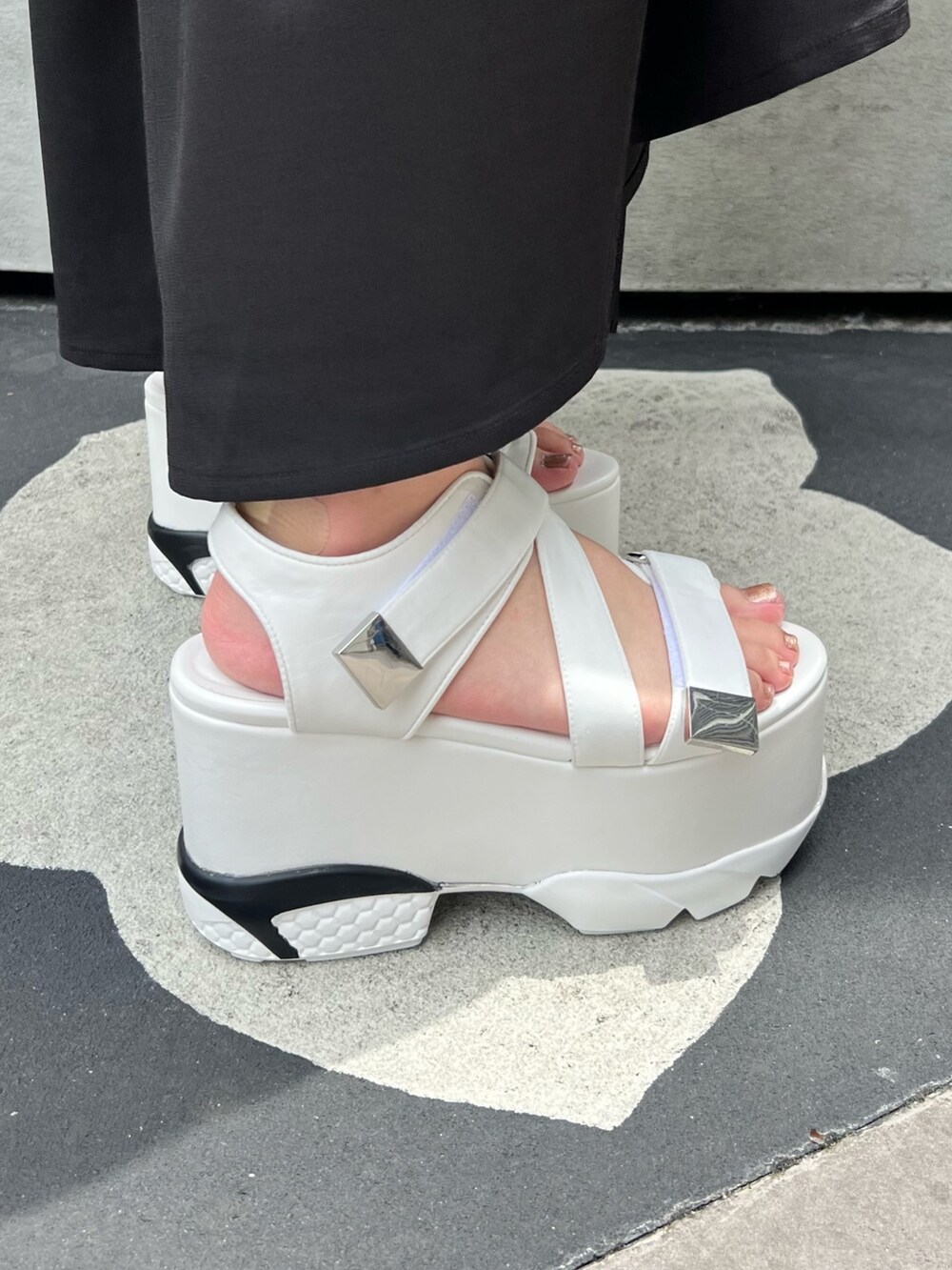 ブラック系のワンピース、ベージュ系のトートバッグ、ホワイト系のサンダルを着用したレディースの夏コーディネートの7枚目の写真