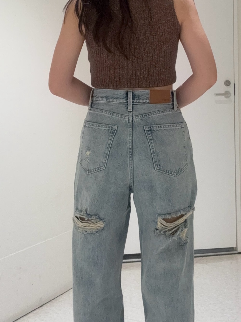 ブラック系のブーツ、ブルー系のデニムパンツ、ブラック系のTシャツ/カットソーを着用したレディースの秋コーディネートの4枚目の写真