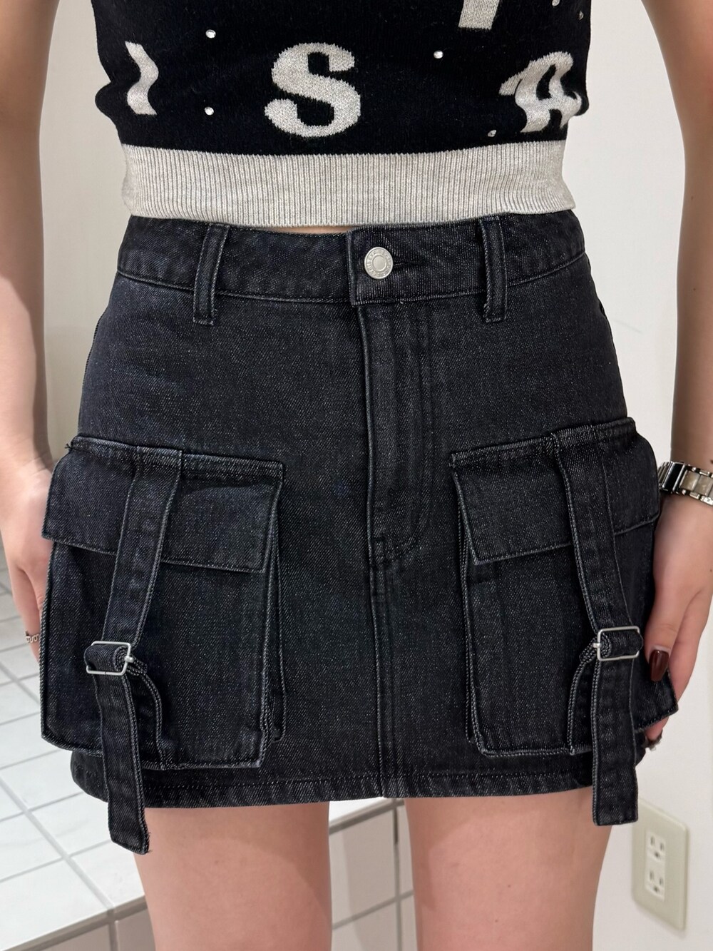 ブラック系のニット/セーター、ブラック系のデニムスカート、ブラック系のブーツを着用したレディースの春コーディネートの5枚目の写真