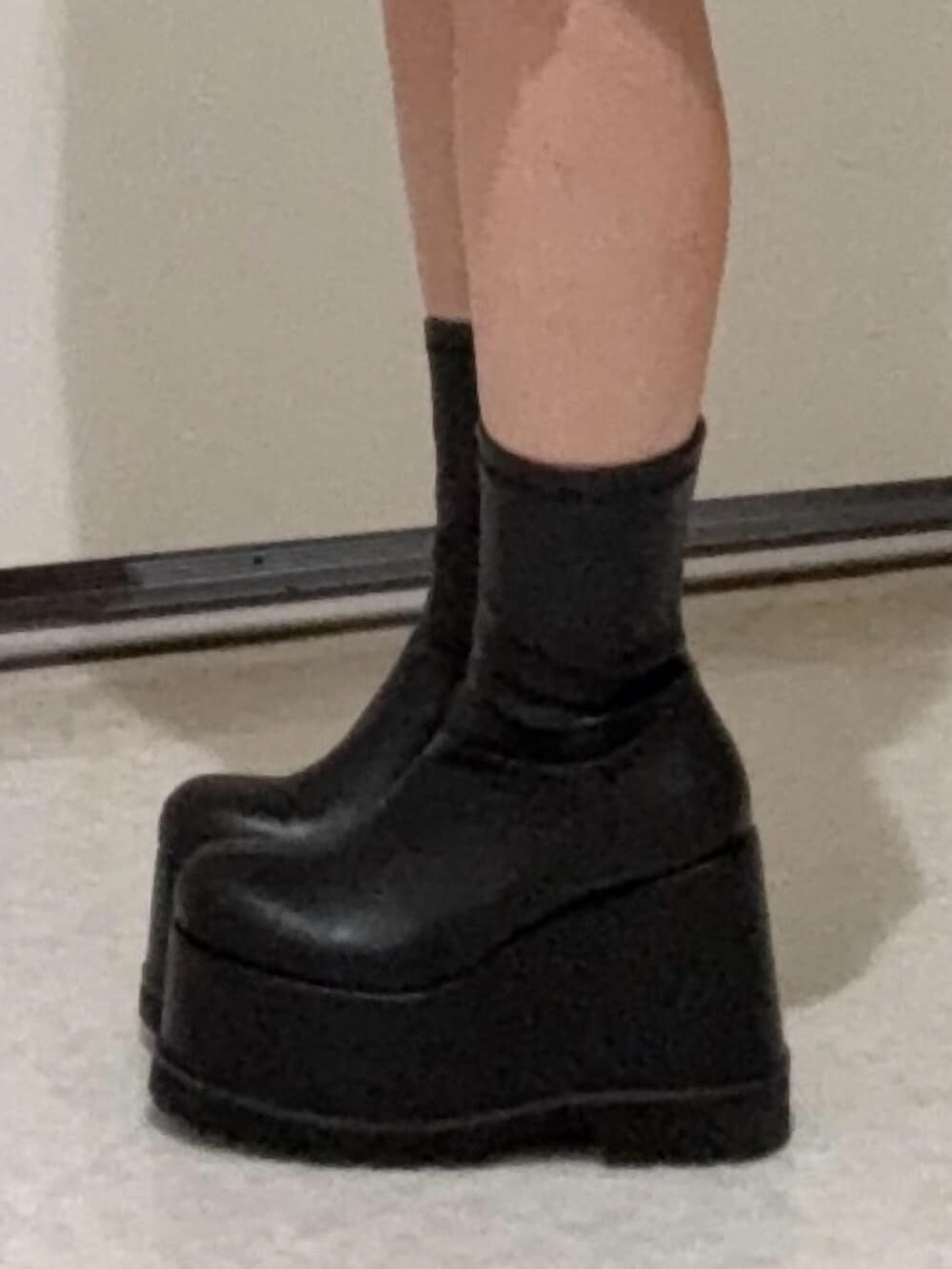 ブラック系のブーツ、ホワイト系のパーカー、ホワイト系のスウェットパンツを着用したレディースの春コーディネートの5枚目の写真