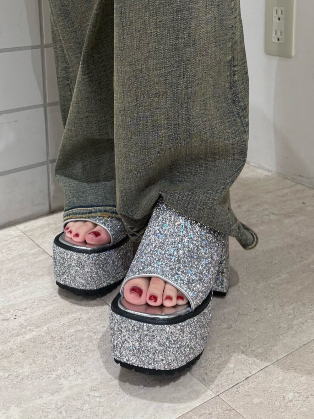 シルバー系のサンダル、レッド系のキャミソール、ブルー系のデニムパンツを着用したレディースの夏コーディネートの5枚目の写真