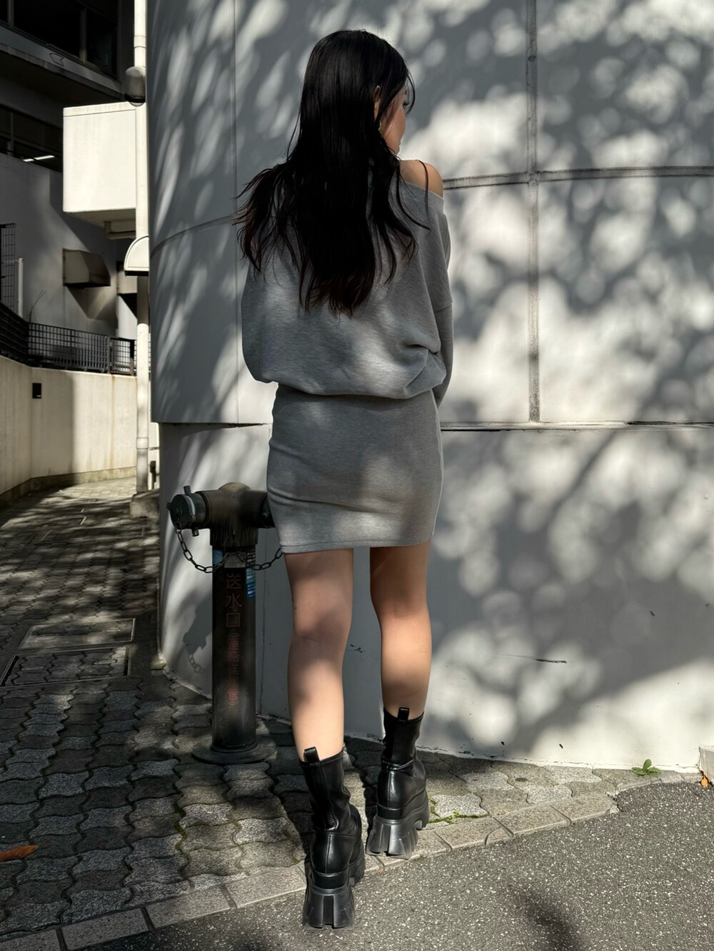 グレー系のワンピース、ブラック系のブーツを着用したレディースの秋コーディネートの5枚目の写真