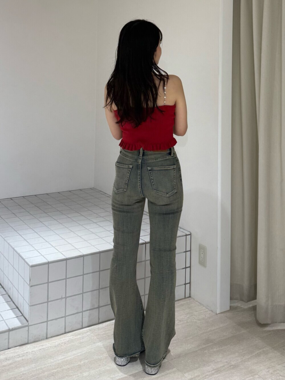シルバー系のサンダル、レッド系のキャミソール、ブルー系のデニムパンツを着用したレディースの夏コーディネートの3枚目の写真