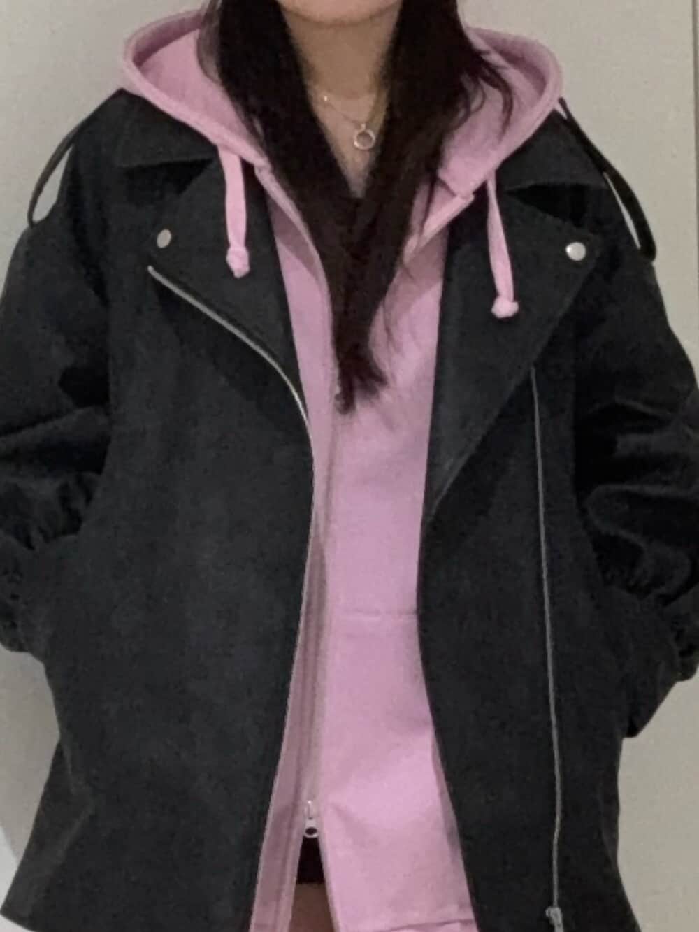 ピンク系のパーカー、ブラック系のライダースジャケット、ブラック系のブーツを着用したレディースの春コーディネートの4枚目の写真