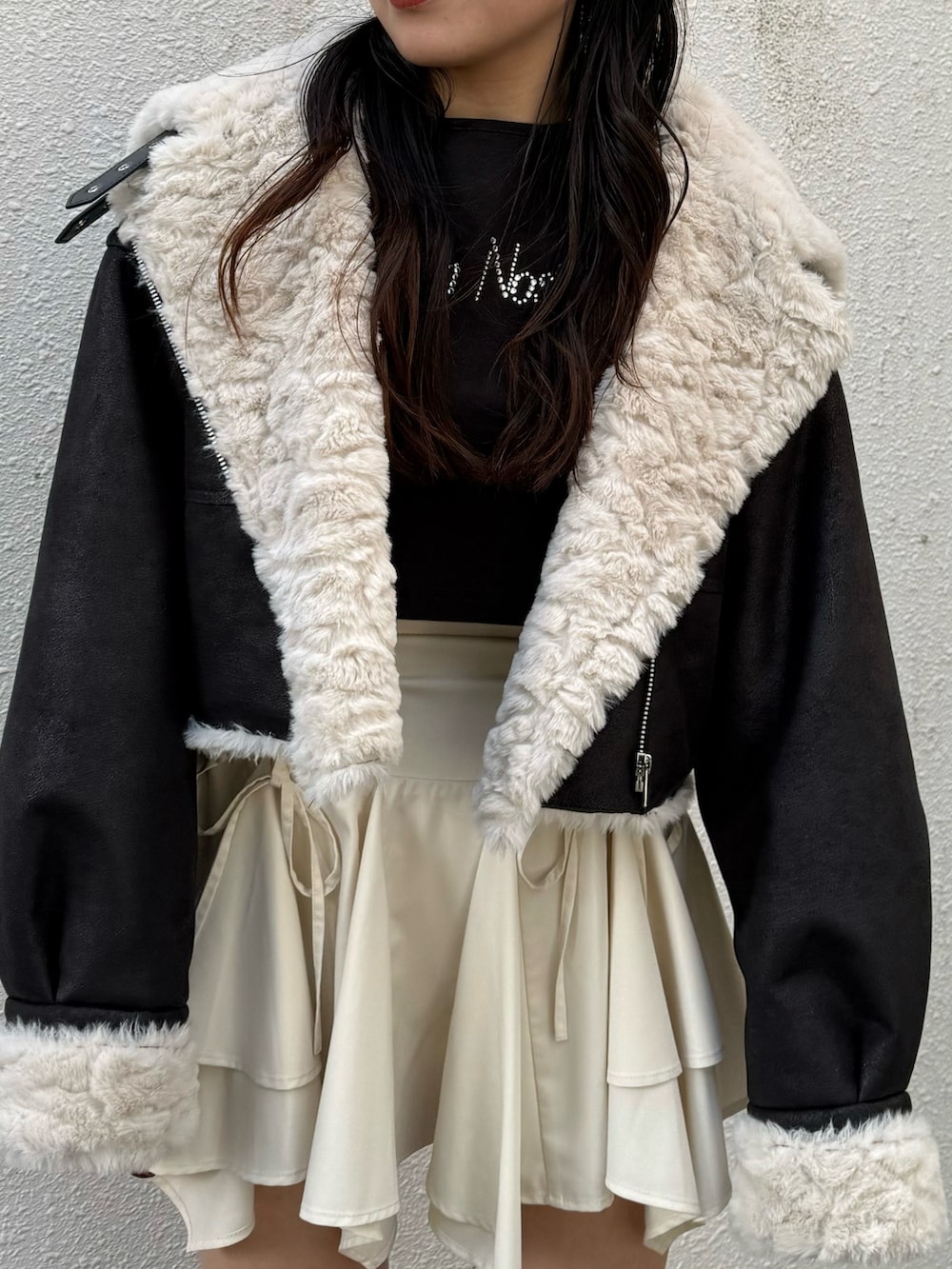 ブラック系のブーツ、ブラック系のブルゾン、ホワイト系のスカートを着用したレディースの秋コーディネートの4枚目の写真