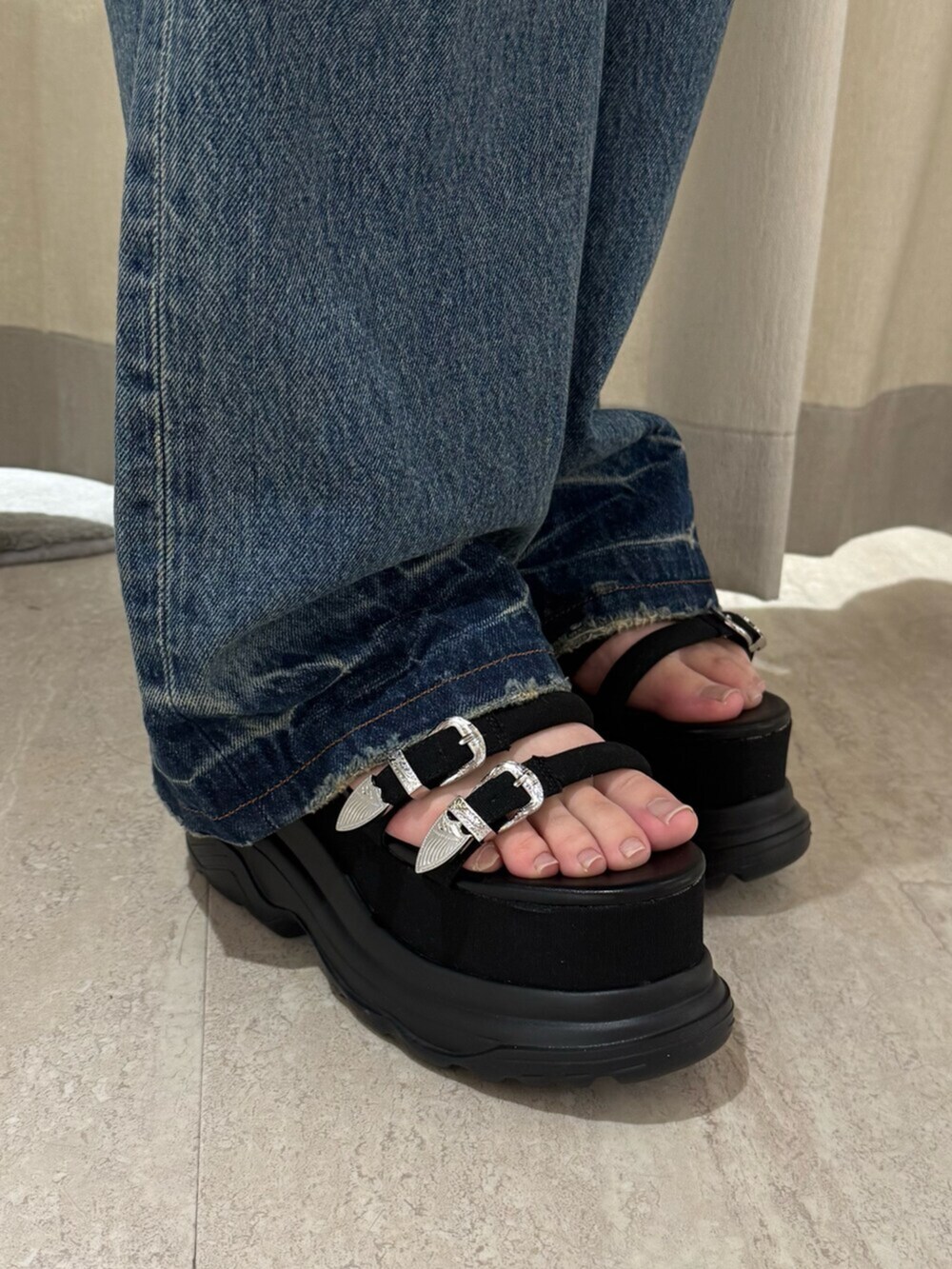 グレー系のワンピース、ブルー系のデニムジャケット、ブラック系のサンダルを着用したレディースの春コーディネートの5枚目の写真