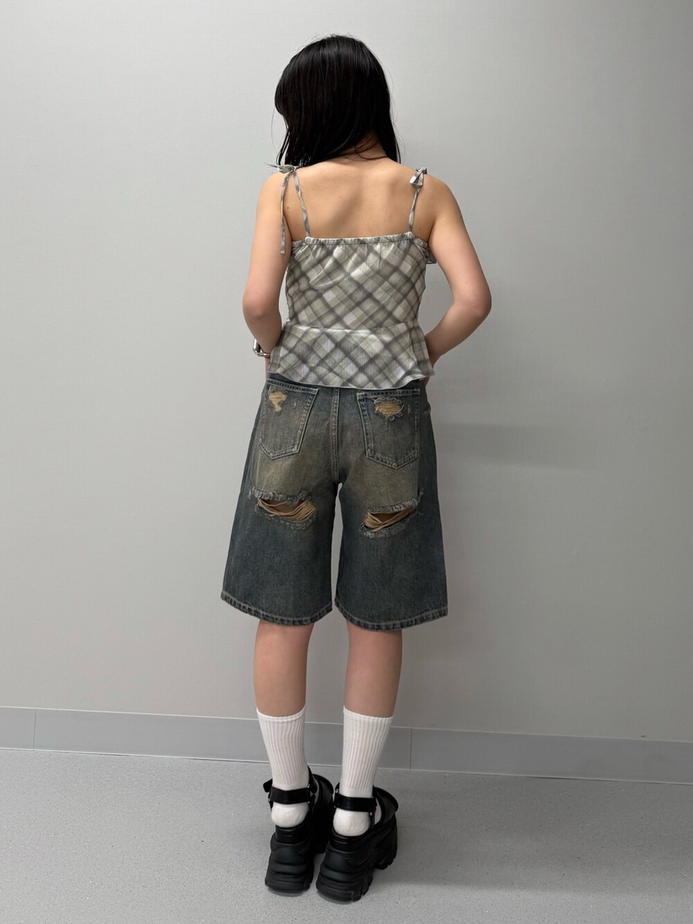 ブルー系のデニムパンツ、イエロー系のキャミソール、ブラウン系のサンダルを着用したレディースの春コーディネートの3枚目の写真