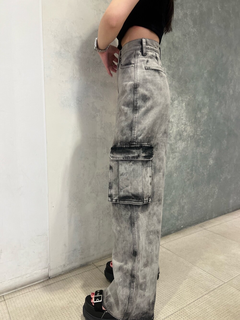 ブラック系のデニムパンツ、ブラック系のキャミソール、ブラック系のサンダルを着用したレディースの夏コーディネートの6枚目の写真