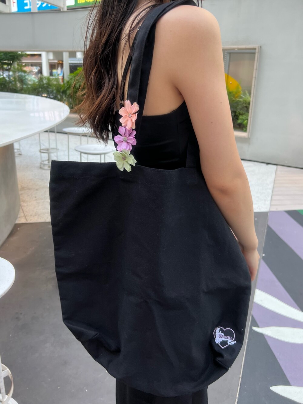 ブラック系のワンピース、ブラック系のトートバッグ、ブラック系のサンダルを着用したレディースの夏コーディネートの10枚目の写真