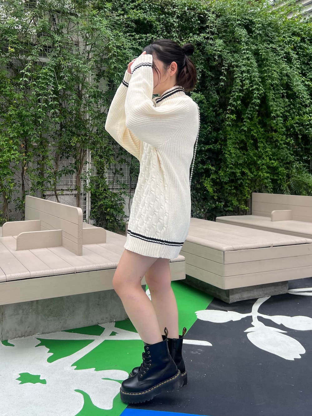 ホワイト系のニット/セーター、ブラック系のブーツ、ブラック系のショルダーバッグを着用したレディースの夏コーディネートの3枚目の写真