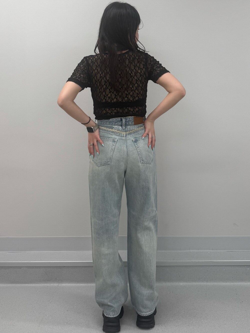 ブルー系のデニムパンツ、ブラウン系のサンダル、ブラック系のTシャツ/カットソーを着用したレディースの春コーディネートの3枚目の写真