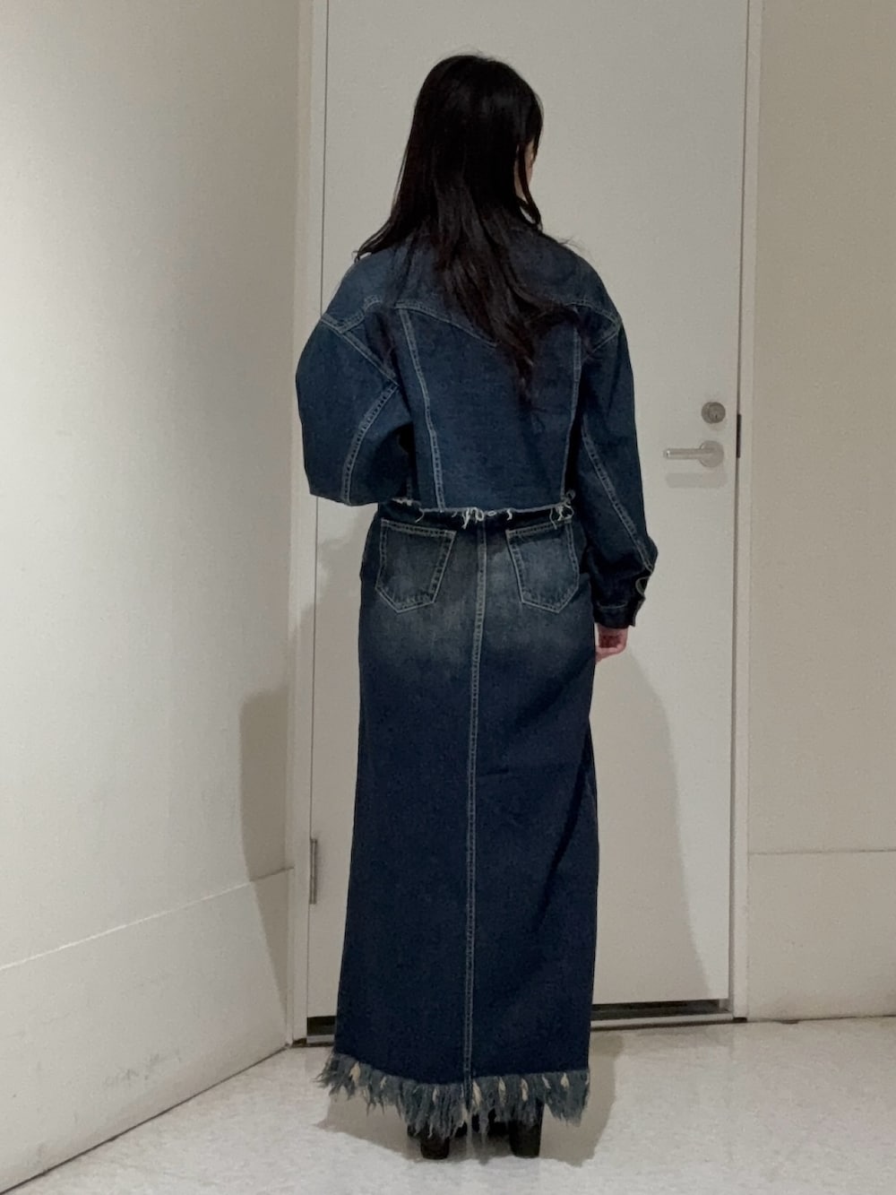 ブルー系のデニムジャケット、ブラック系のブーツ、ブルー系のデニムスカートを着用したレディースの冬コーディネートの3枚目の写真