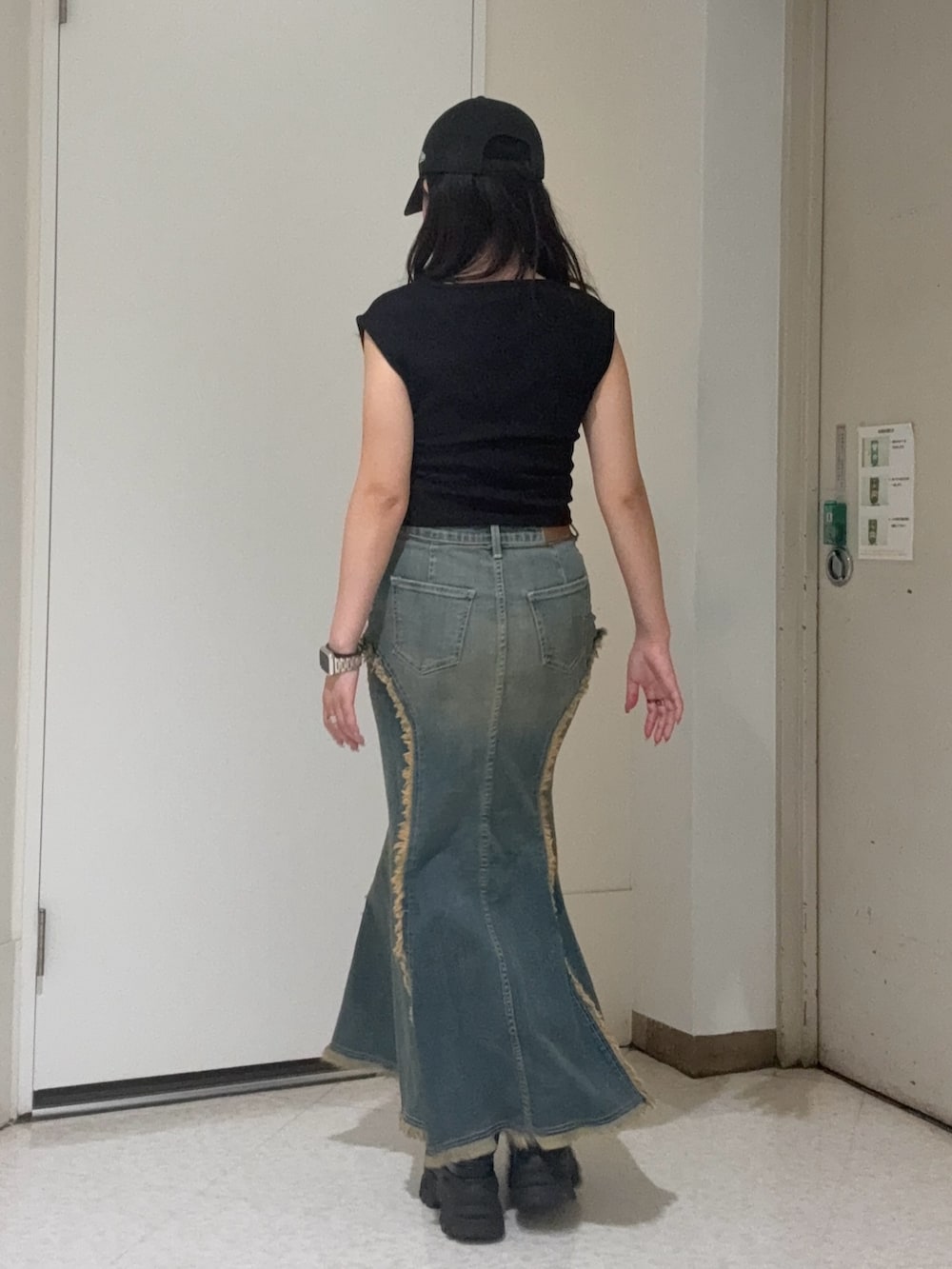 ブラック系のタンクトップ、ブルー系のデニムスカート、ブラウン系のサンダルを着用したレディースの夏コーディネートの3枚目の写真