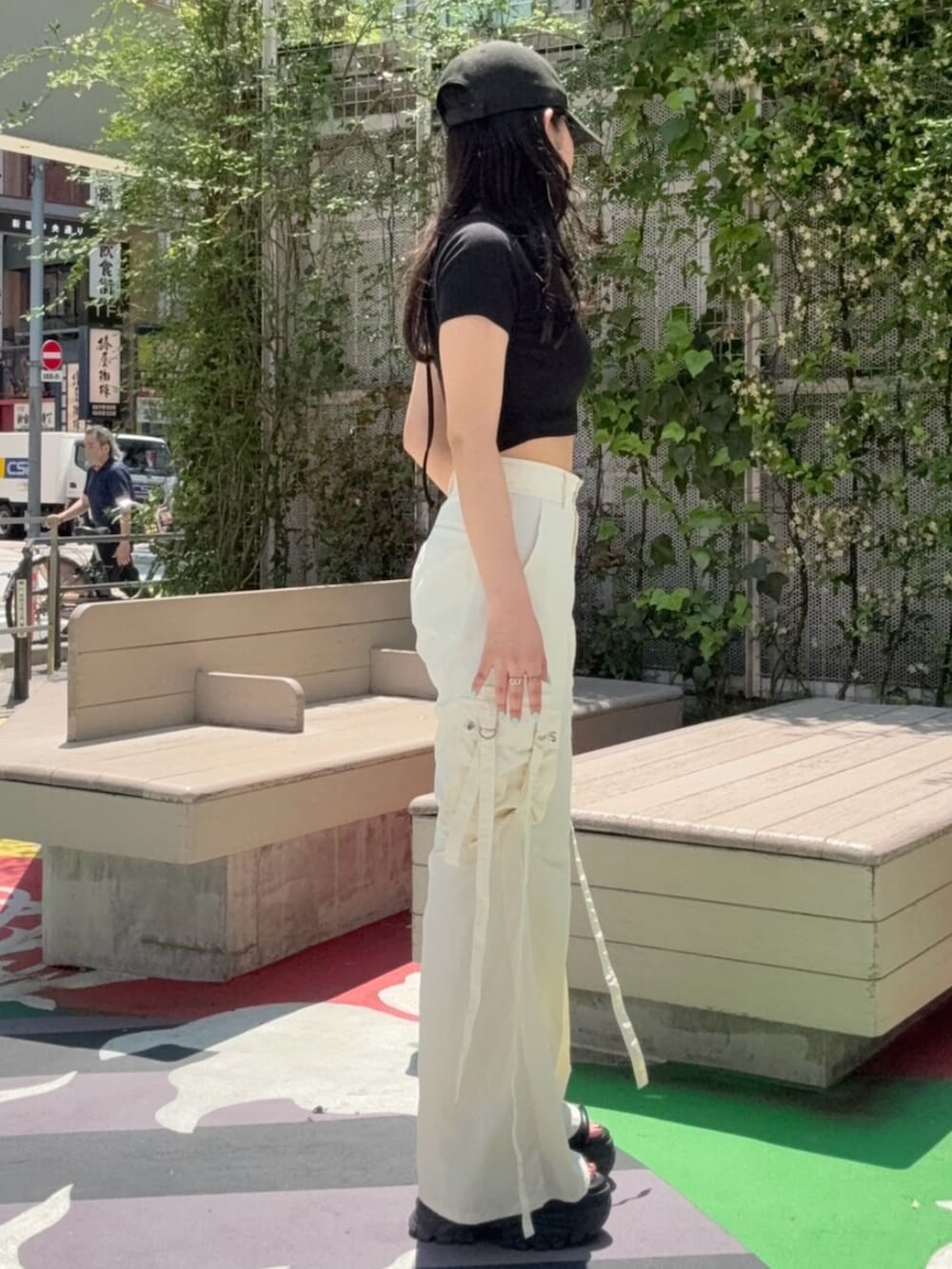 ブラウン系のサンダル、ブラック系のTシャツ/カットソー、ホワイト系のカーゴパンツを着用したレディースの春コーディネートの2枚目の写真