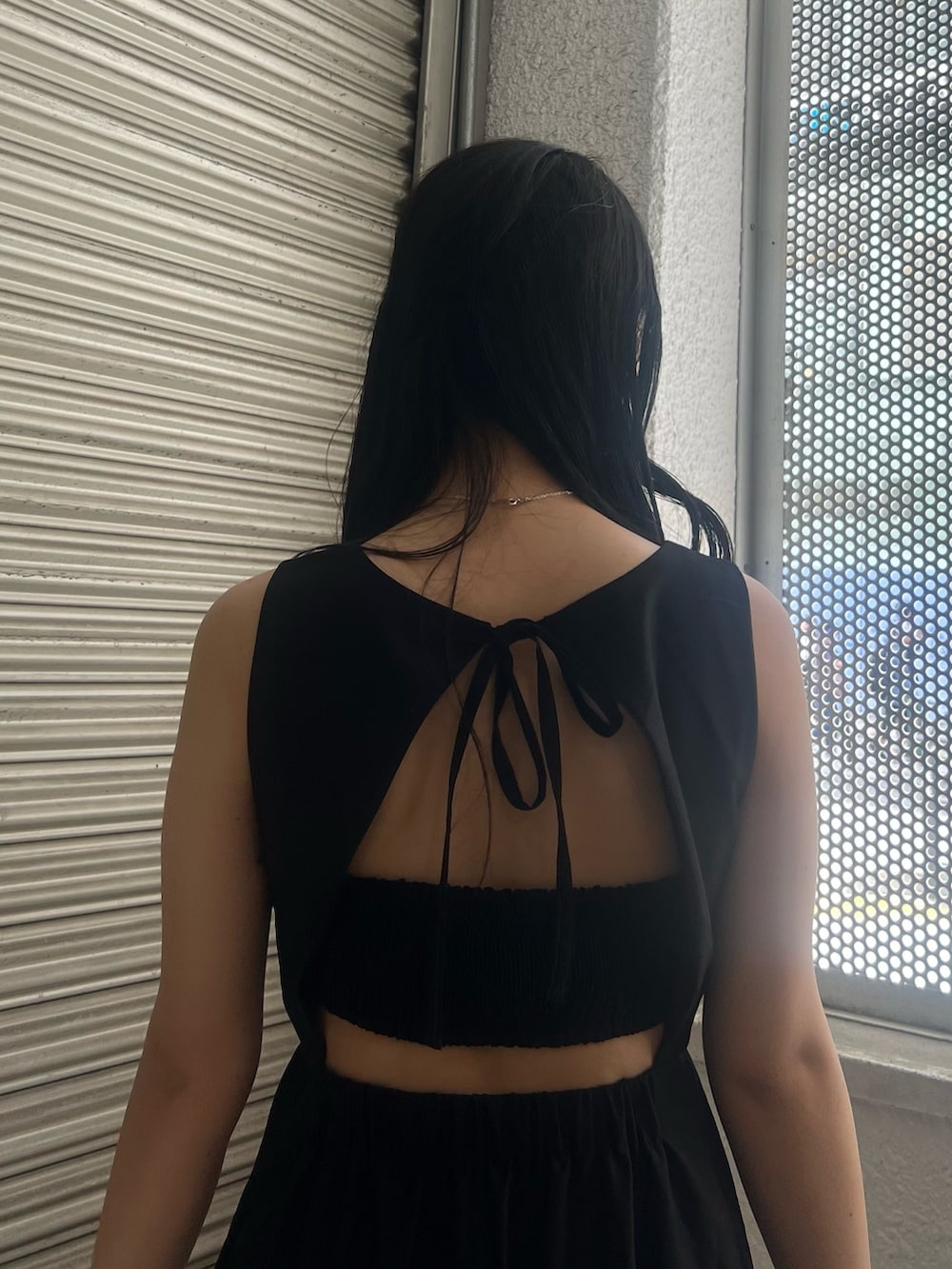 ブラック系のワンピース、ホワイト系のサンダルを着用したレディースの夏コーディネートの5枚目の写真