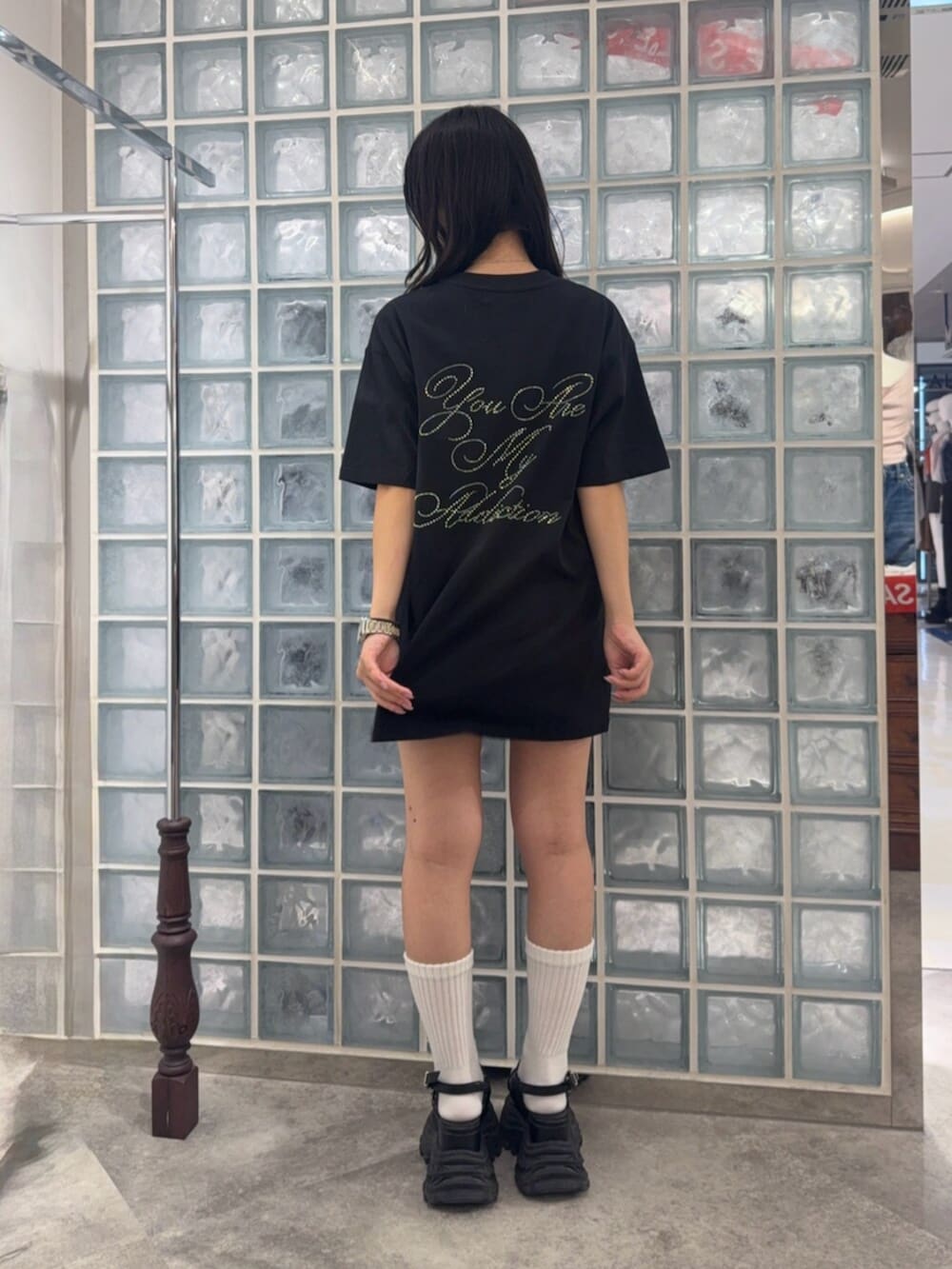 ブラック系のサンダル、ブラック系のTシャツ/カットソーを着用したレディースの夏コーディネートの3枚目の写真