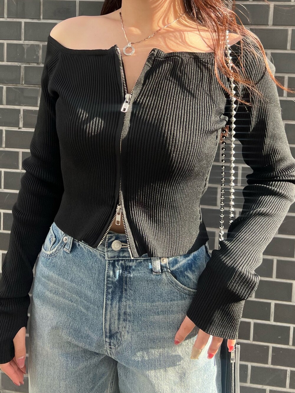 ブルー系のデニムパンツ、ブラック系のニット/セーター、ブラック系のサンダルを着用したレディースの春コーディネートの5枚目の写真