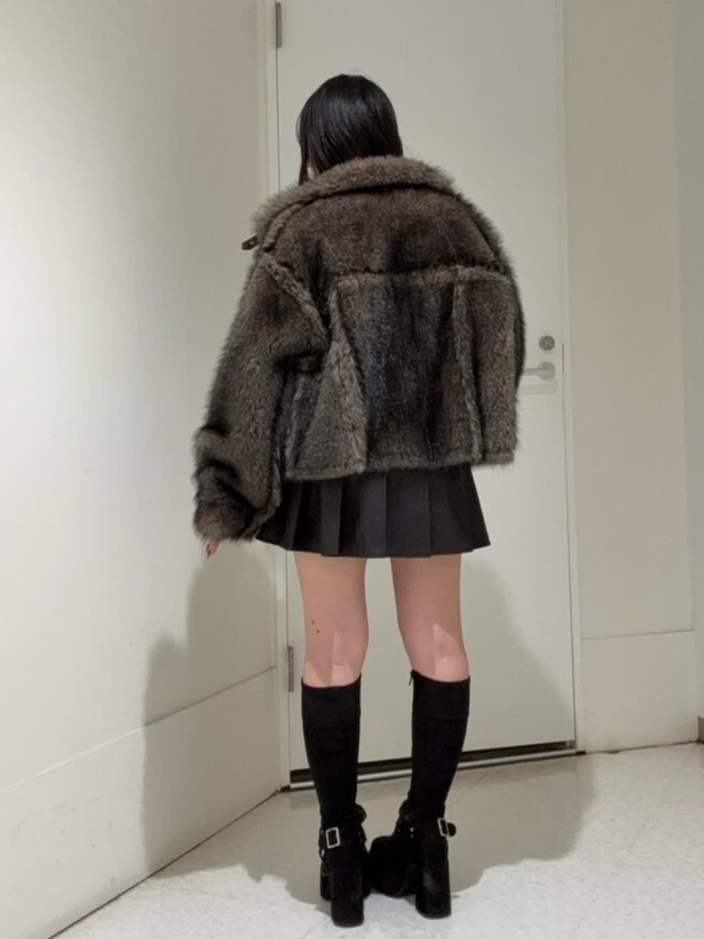 ブラック系のブーツ、ブラウン系のブルゾン、ブラック系のスカートを着用したレディースの秋コーディネートの3枚目の写真