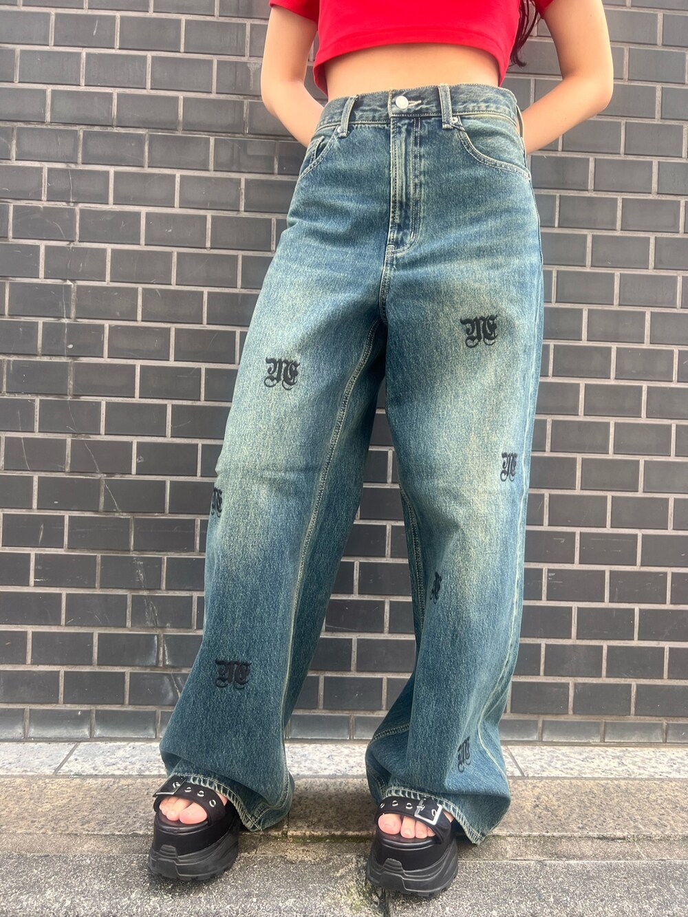 レッド系のTシャツ/カットソー、ブルー系のデニムパンツ、ブラック系のサンダルを着用したレディースの春コーディネートの6枚目の写真