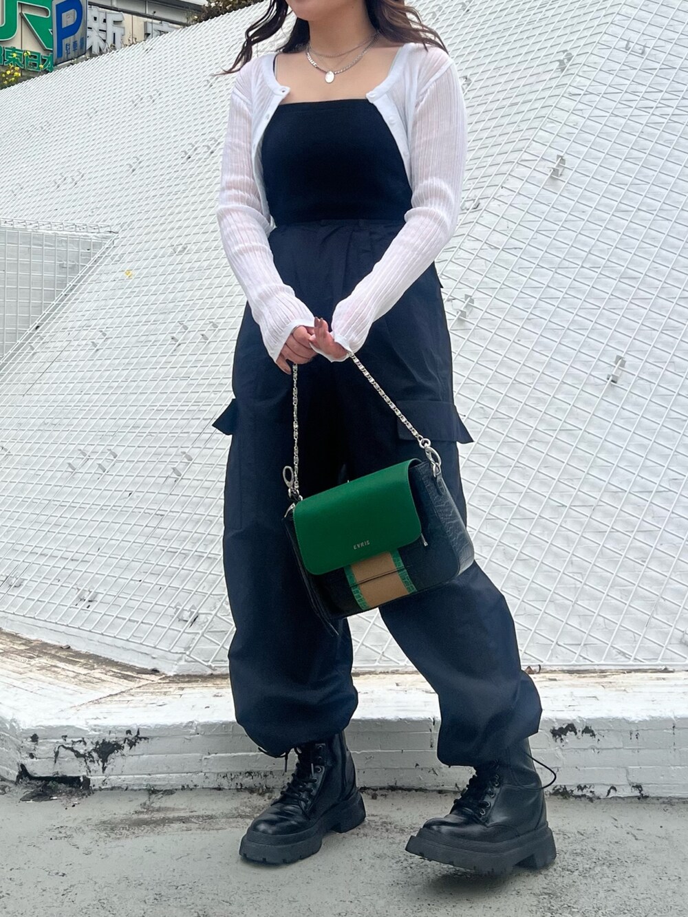 ブラック系のカーゴパンツ、ブラック系のブーツ、ホワイト系のカーディガン/ボレロを着用したレディースの春コーディネートの3枚目の写真