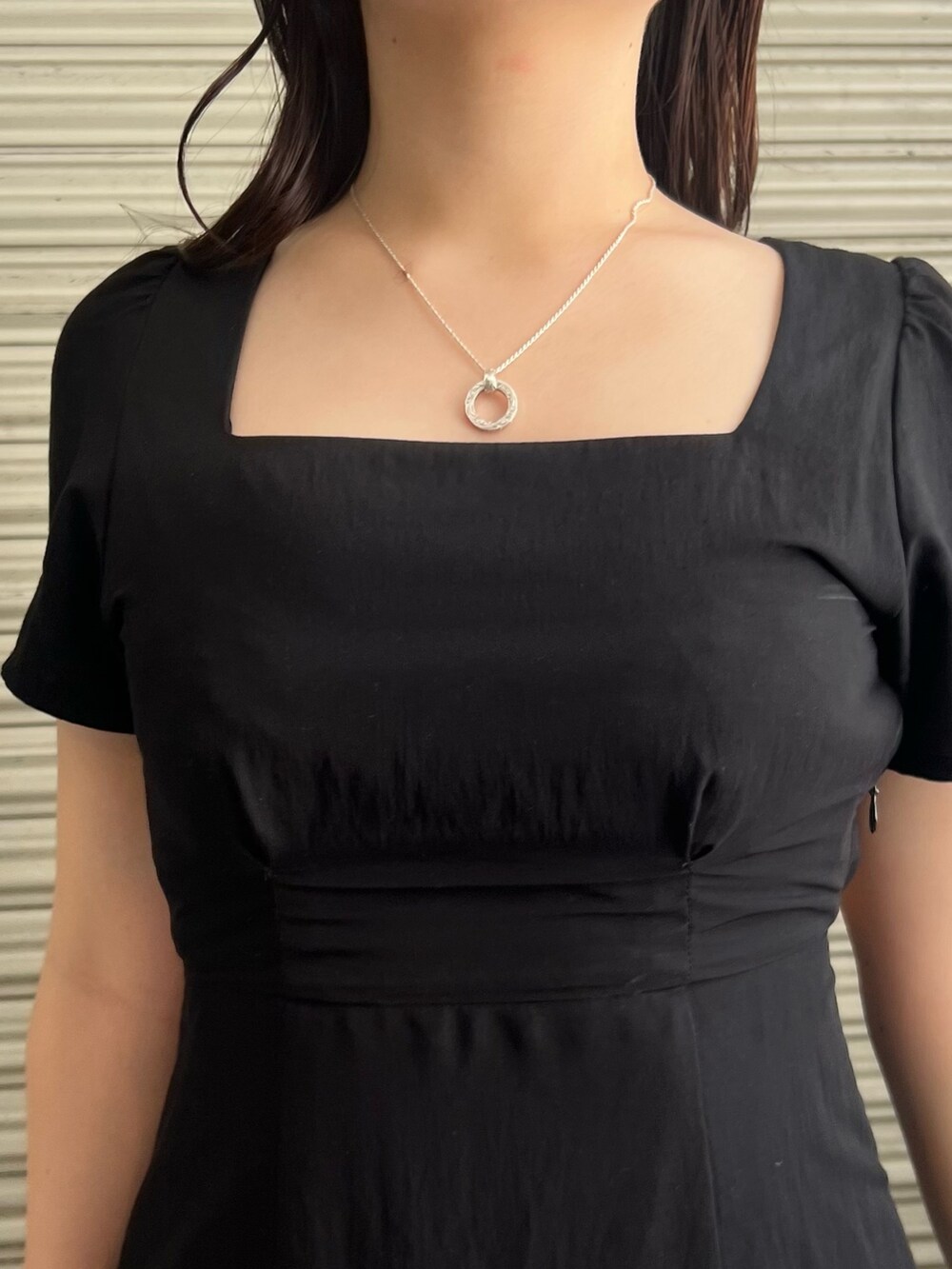 ブラック系のワンピース、ブラック系のショルダーバッグ、ブラック系のサンダルを着用したレディースの夏コーディネートの5枚目の写真