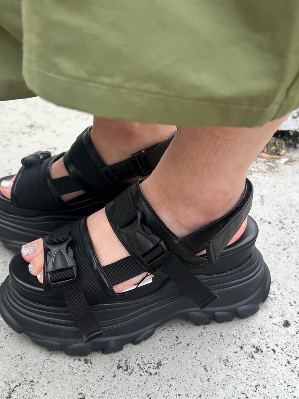 ホワイト系のハンドバッグ、グリーン系のカーゴパンツ、ブラック系のサンダルを着用したレディースの春コーディネートの6枚目の写真