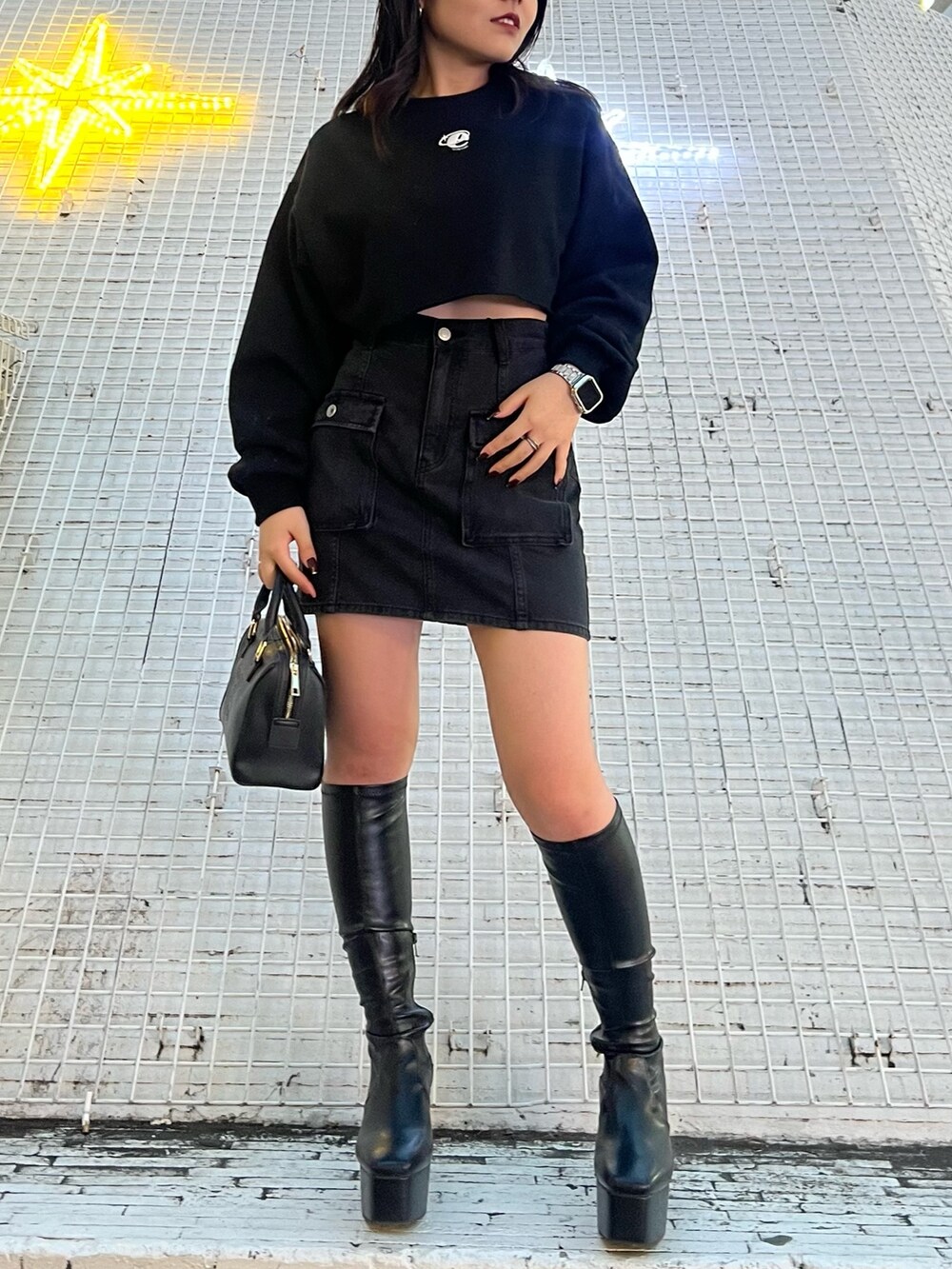 ブラック系のブーツ、ブラック系のデニムスカート、ブラック系のスウェットを着用したレディースの冬コーディネートの3枚目の写真