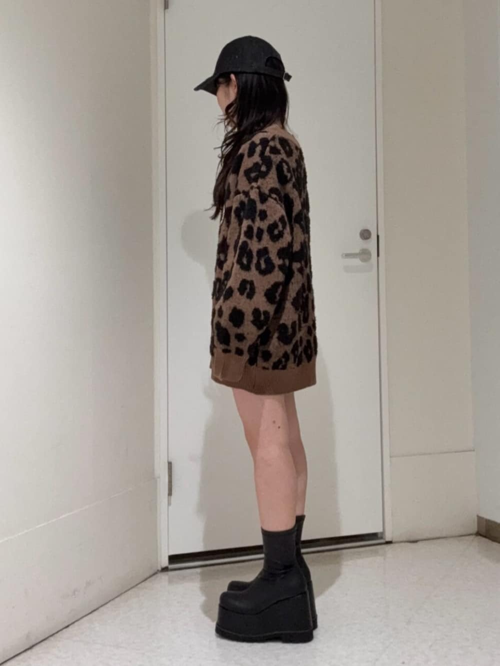 ブラック系のブーツ、ブルー系のデニムパンツ、ブラウン系のカーディガン/ボレロを着用したレディースの冬コーディネートの2枚目の写真