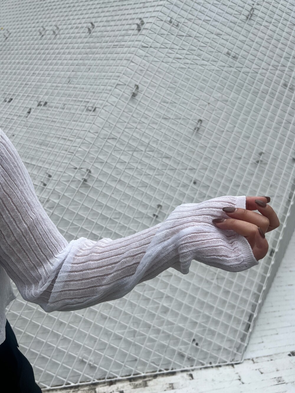 ブラック系のカーゴパンツ、ブラック系のブーツ、ホワイト系のカーディガン/ボレロを着用したレディースの春コーディネートの6枚目の写真