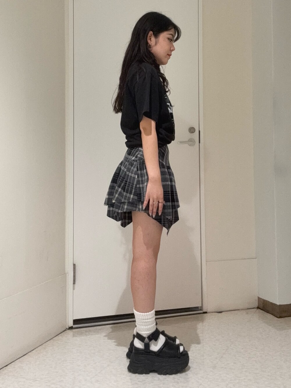 ブラック系のスカート、ブラック系のTシャツ/カットソー、ブラウン系のサンダルを着用したレディースの夏コーディネートの2枚目の写真