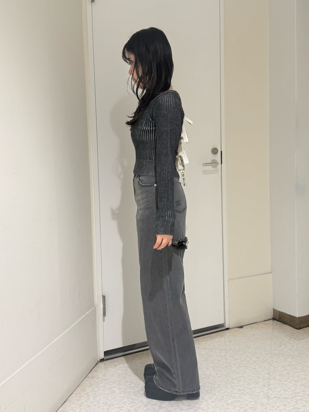 ブラック系のブーツ、ブラウン系のニット/セーター、ブラック系のデニムパンツを着用したレディースの秋コーディネートの2枚目の写真