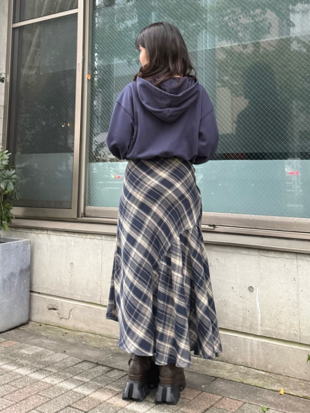 ブルー系のスカート、ブルー系のパーカー、ブラウン系のブーツを着用したレディースの秋コーディネートの3枚目の写真