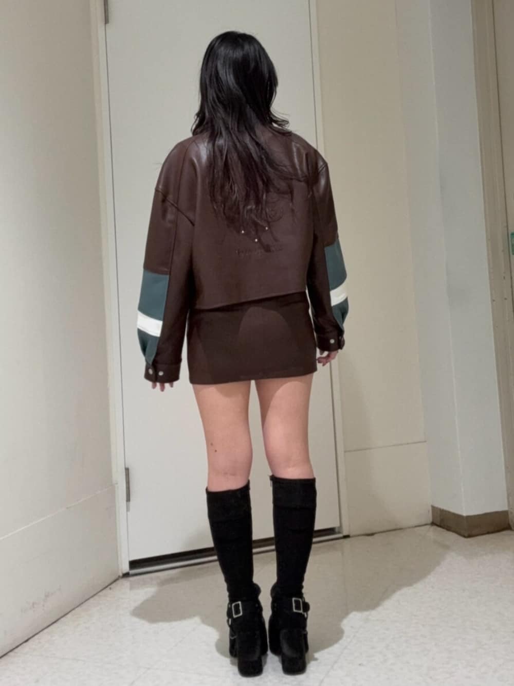 ブラック系のブーツ、ブラウン系のスカート、ブラウン系のブルゾンを着用したレディースの冬コーディネートの3枚目の写真