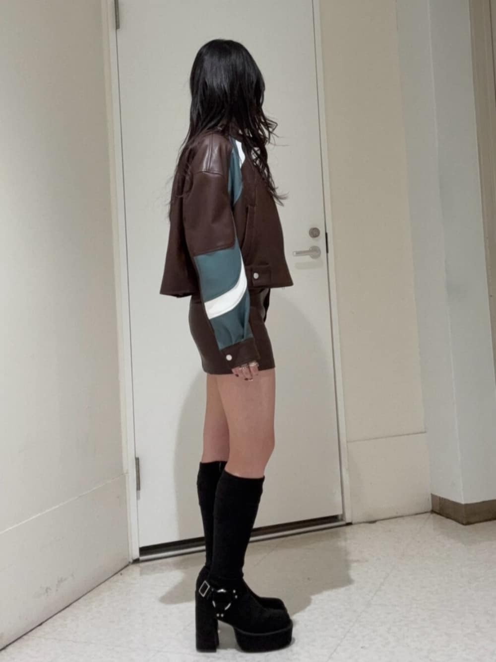 ブラック系のブーツ、ブラウン系のスカート、ブラウン系のブルゾンを着用したレディースの冬コーディネートの2枚目の写真