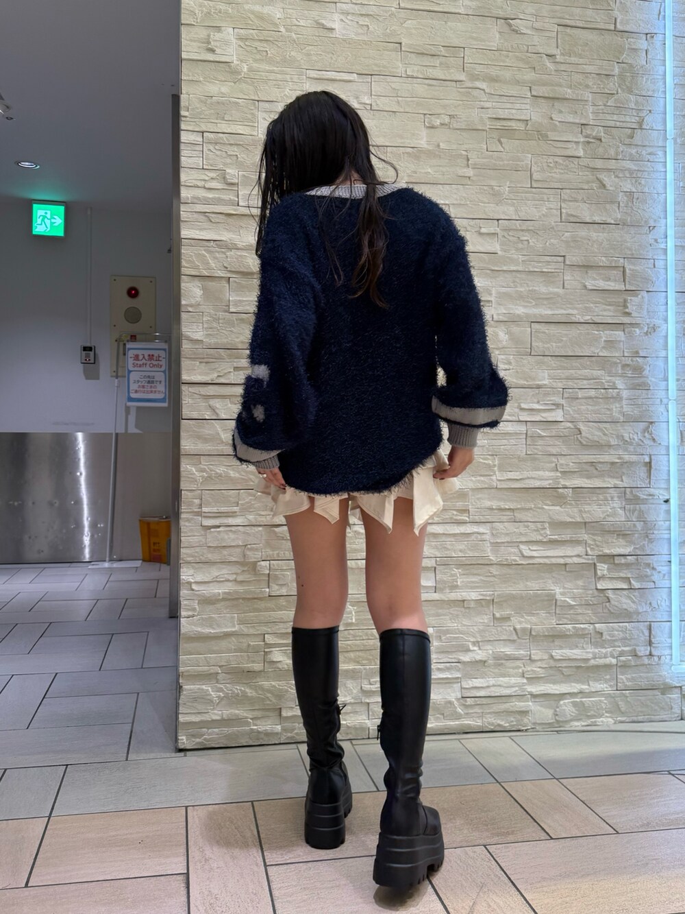 ホワイト系のスカート、ブラック系のブーツ、ブルー系のニット/セーターを着用したレディースの秋コーディネートの4枚目の写真