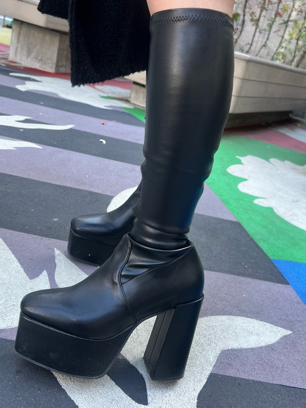 ホワイト系のカーディガン/ボレロ、ブラック系のブーツ、シルバー系のハンドバッグを着用したレディースの冬コーディネートの8枚目の写真