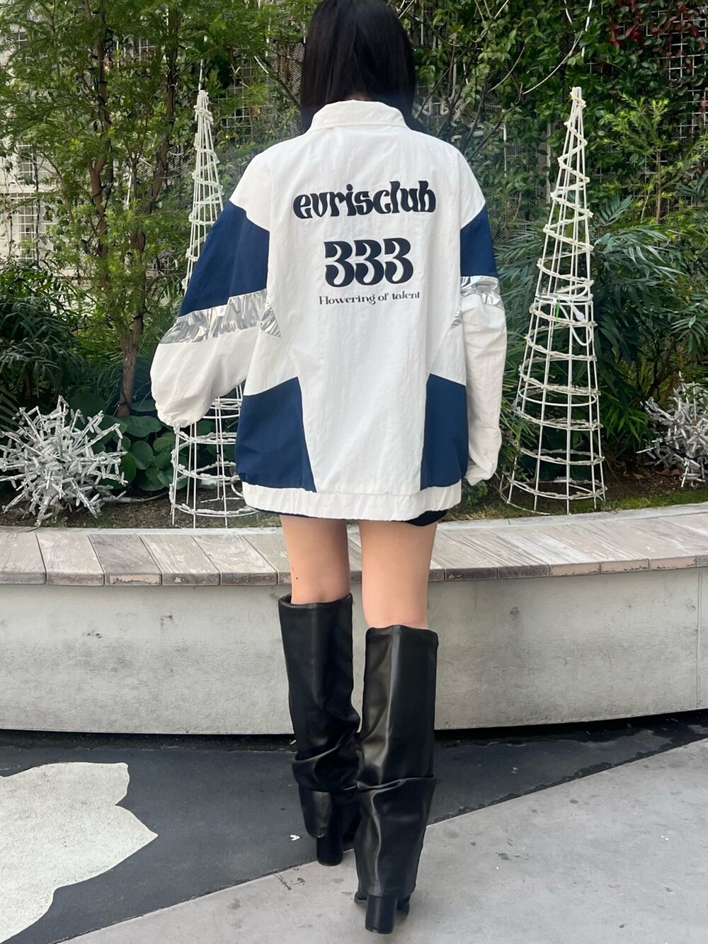 ホワイト系のナイロンジャケット、シルバー系のボディバッグ/ウエストポーチ、ブラック系のブーツを着用したレディースの冬コーディネートの5枚目の写真