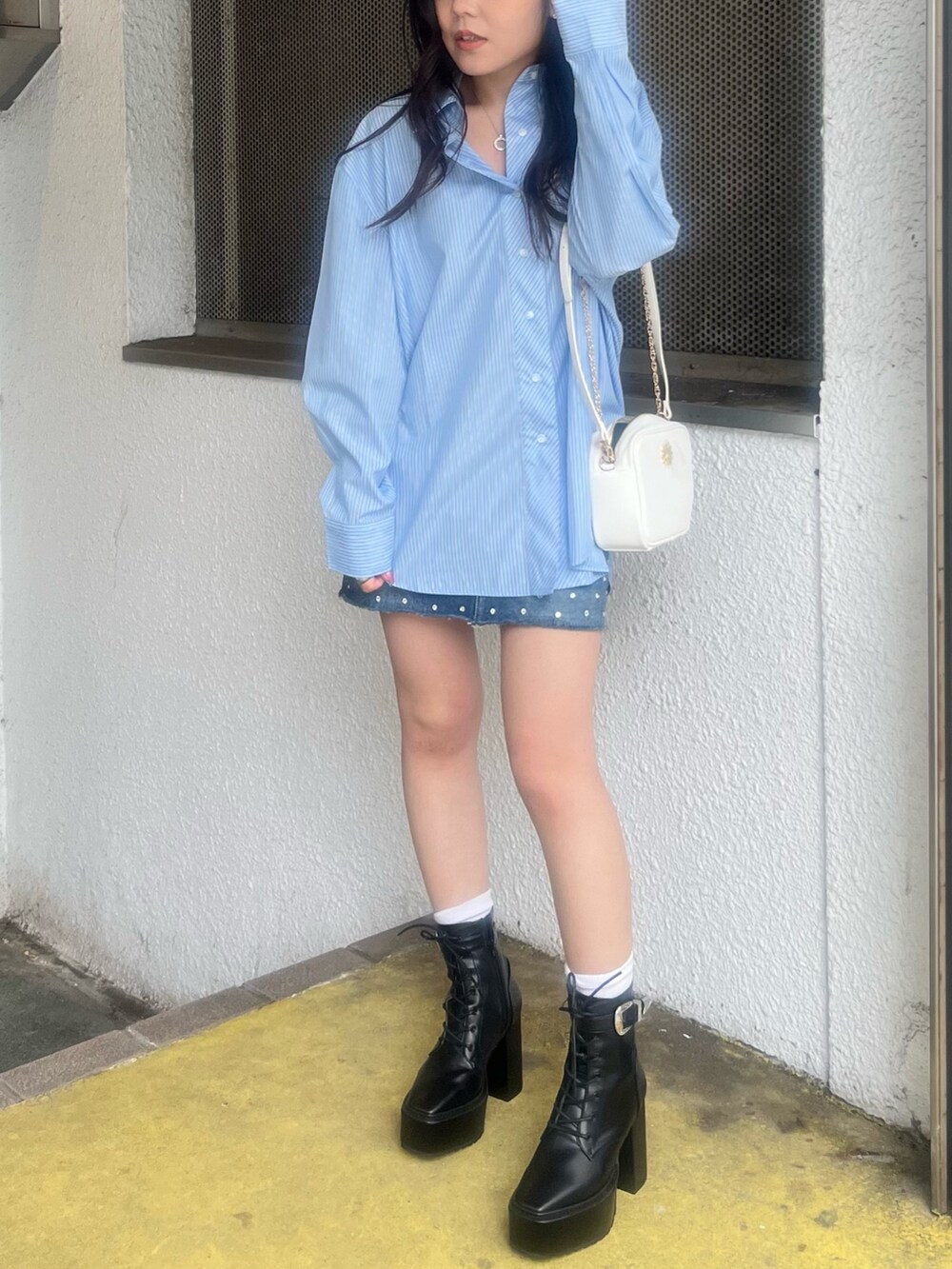 ブルー系のデニムスカート、ブルー系のシャツ/ブラウス、ホワイト系のショルダーバッグを着用したレディースの春コーディネートの2枚目の写真