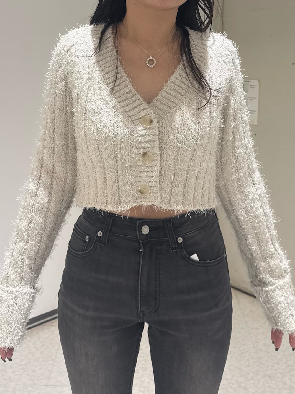 ブラック系のブーツ、ブラック系のデニムパンツ、ホワイト系のカーディガン/ボレロを着用したレディースの秋コーディネートの4枚目の写真