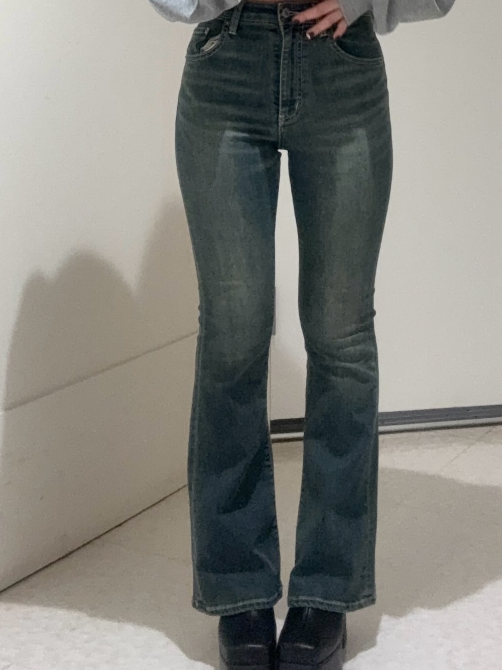 ブラック系のブーツ、ブルー系のデニムパンツ、ブラウン系のタンクトップを着用したレディースの秋コーディネートの5枚目の写真