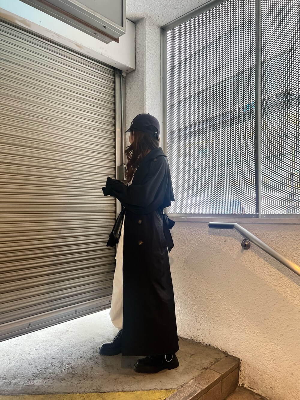 ブラック系のトレンチコート、ホワイト系のカーゴパンツ、ブラック系のショルダーバッグを着用したレディースの春コーディネートの4枚目の写真